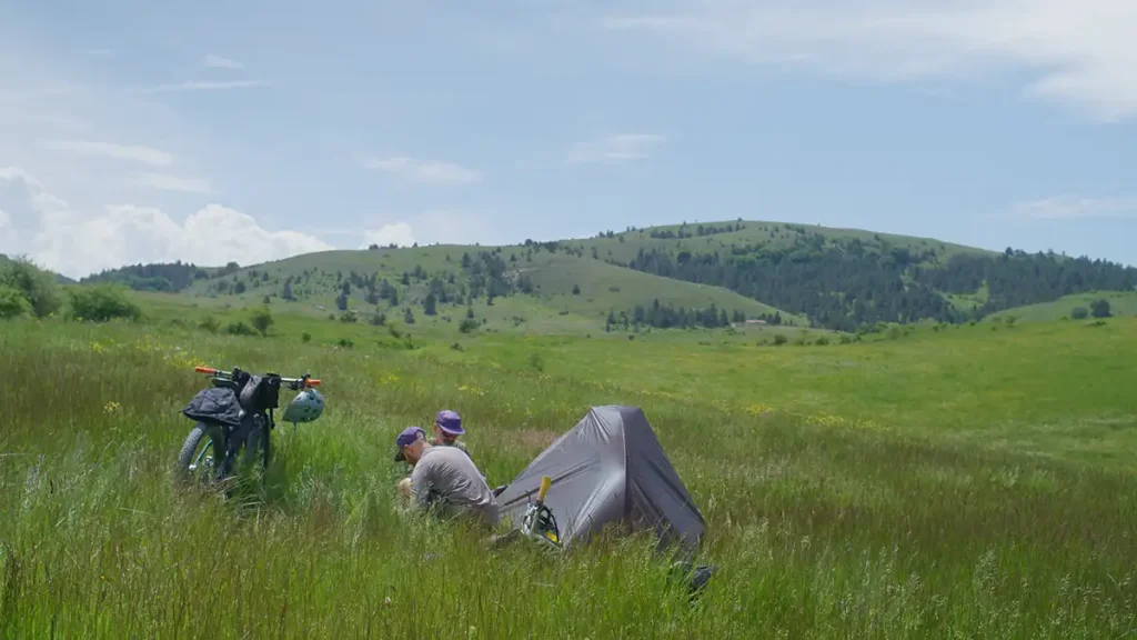 Il filmmaker Simone De Gasperis impegnato in riprese outdoor con attrezzatura professionale durante un progetto di cicloturismo